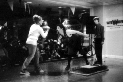 Travis Fessler asks a member of the audience to remove his sword
 [This photograph is copyright � 2006 James G. Mundie. All rights reserved.]